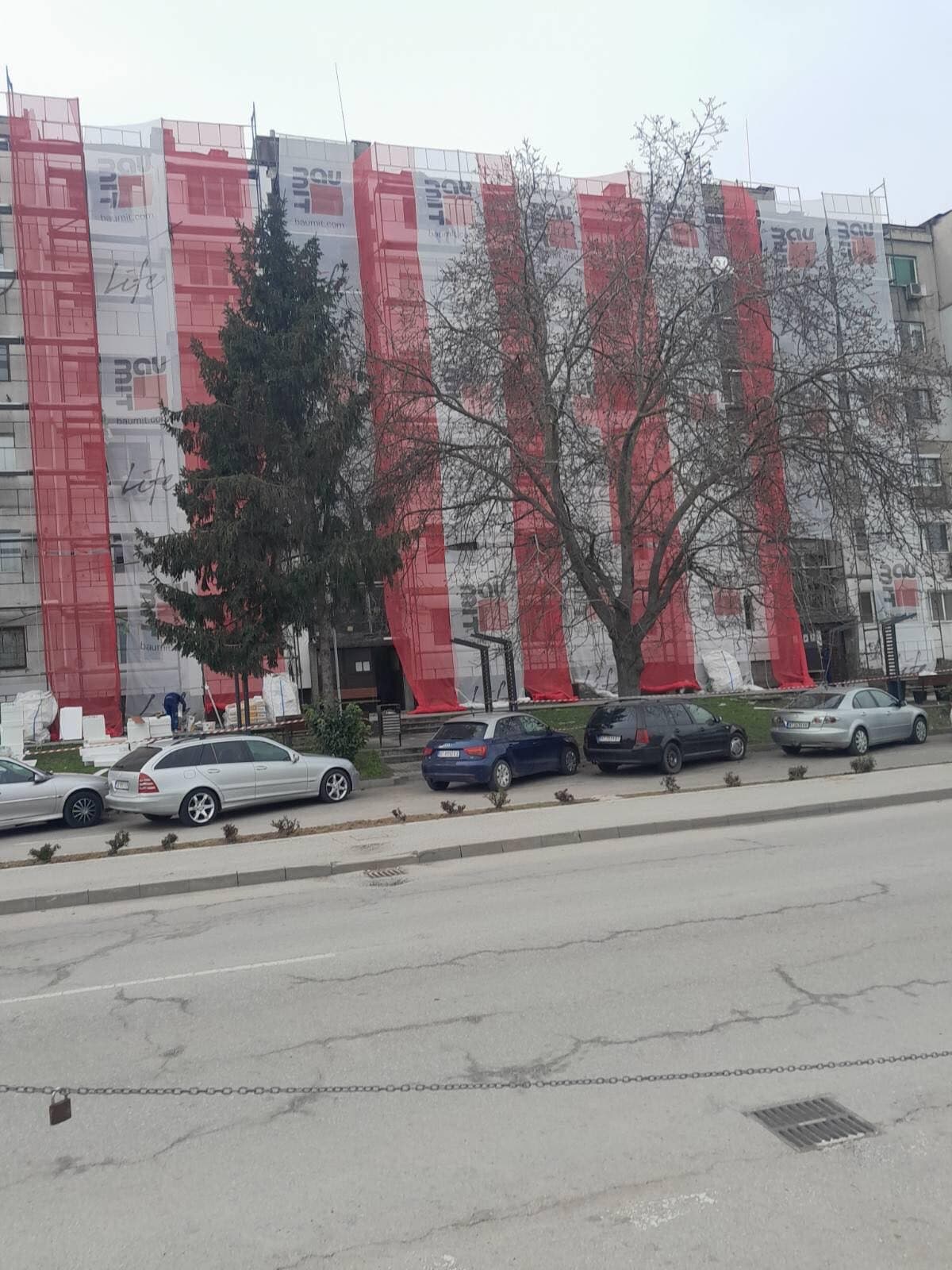 Блок със защитно платно и скеле покрай улицата